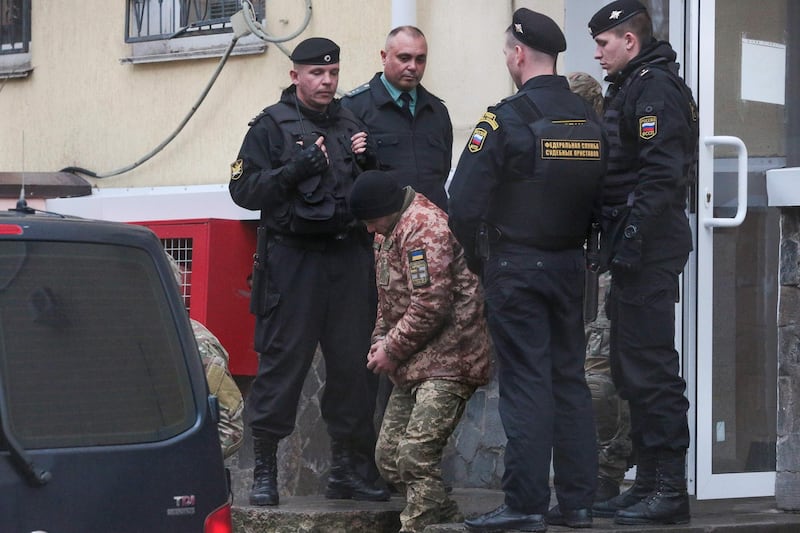A detained Ukrainian sailor is escorted to a car after a court hearing in Simferopol, Crimea. AFP