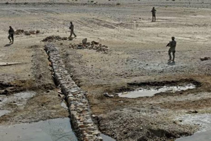 In this photo provided by ISAF Regional Command (South), members of Provincial Reconstruction Team Zabul inspect a canal project site, Tuesday, June 14, 2011, in the Zabul Province of Afghanistan. (AP Photo/ U.S. Air Force Staff Sgt. Brian Ferguson)