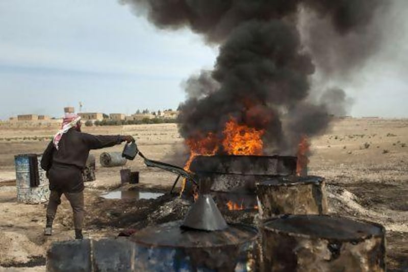 Ahmed, a 35-year-old farmer-turned-refiner, works on refining crude oil brought from Deir Ezzor province into a pit in the Al Raqqa countryside where it will be distilled as part of the refining process to produce fuel.