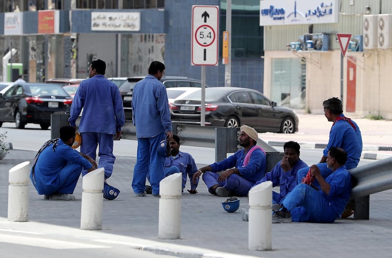 DUBAI , UNITED ARAB EMIRATES , JUNE 14 – 2018 :- Labourers waiting for their staff bus after the midday break at one of the construction site in Al Garhoud area in Dubai. ( Pawan Singh / The National )  For News. Story by Ramola
