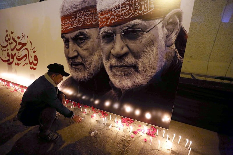 A supporter of Iraqi Shiite Popular Mobilisation Forces lights candles at the site of US drone attack that killed Qassem Suleimani and Abu Mahdi Al Muhandis. EPA