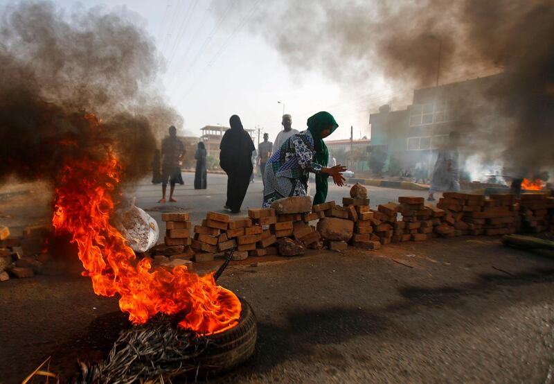 TOPSHOT - Sudanese protesters close Street 60 with burning tyres and pavers as military forces tried to disperse a sit-in outside Khartoum's army headquarters on June 3, 2019. At least two people were killed Monday as Sudan's military council tried to break up a sit-in outside Khartoum's army headquarters, a doctors' committee said as gunfire was heard from the protest site.
 / AFP / ASHRAF SHAZLY
