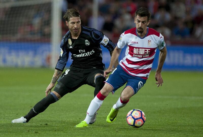 Granada midfielder Isaac Cuenca, right, vies with Real Madrid defender Sergio Ramos. Sergio Camacho / AFP