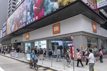 Pedestrians walk past a Xiaomi store in Hong Kong. Bloomberg