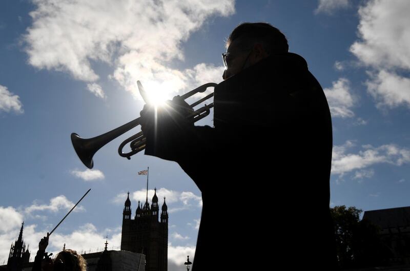 A trumpet player is silhouetted outside the houses of Parliament. Reuters