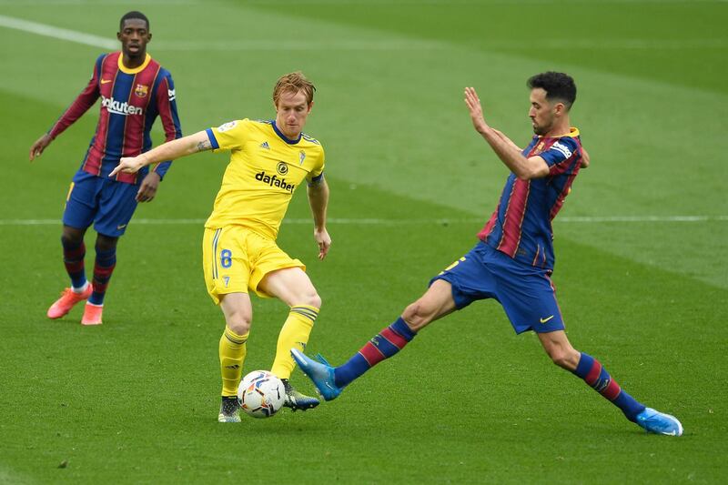 Barcelona midfielder Sergio Busquets challenges Cadiz goalscorer Alex Fernandez. AFP