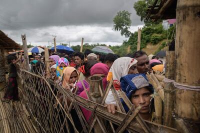 TOPSHOT - Rohingya refugees queue at an aid relief distribution centre at the Balukhali refugee camp near Cox's Bazar on August 12, 2018. (Photo by Ed JONES / AFP)