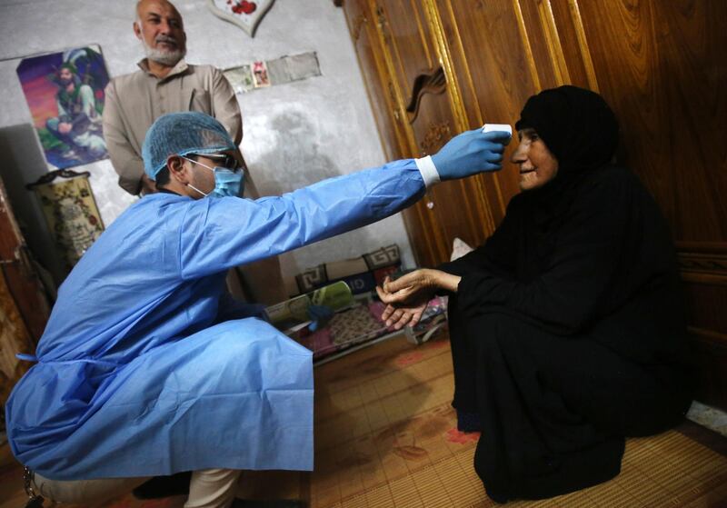 An Iraqi public hospital specialised doctor checks a woman's temperature for COVID-19 in the capital Baghdad's suburb of Sadr City, as part of actions taken by the authorities against the spread of the novel coronavirus. The process of examining citizens at their residences in Baghdad's eastern districts was launched in order to detect infection with the virus in the area where many cases were found to isolate patients and take them for treatment in public hospitals to limit the spread of the pandemic. AFP