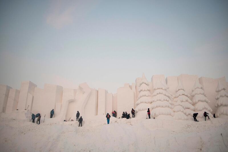 Workers carve their snow sculptures. AFP