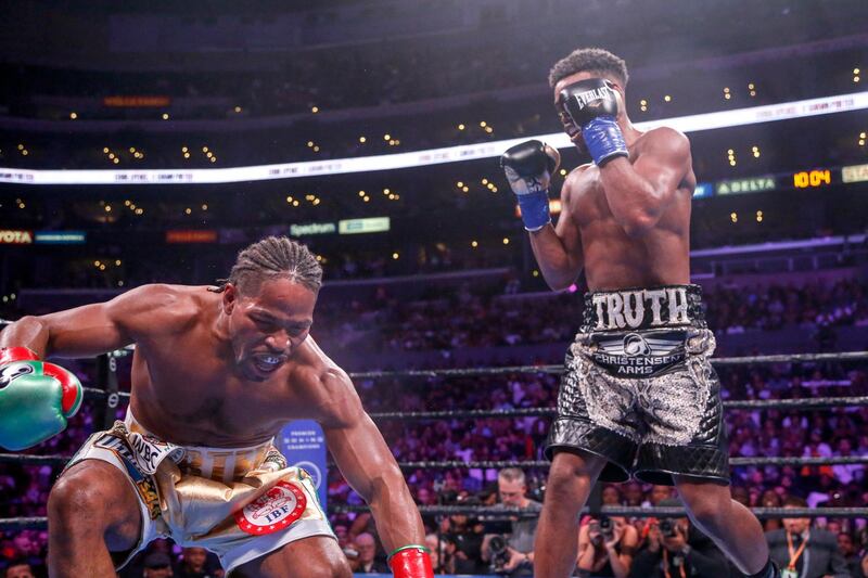 Shawn Porter, left, is knocked down by Errol Spence Jr during the 11th round. AP Photo