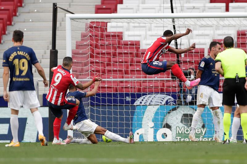 Luis Suarez, left, scores Atletico Madrid's second goal against Osasuna. AP