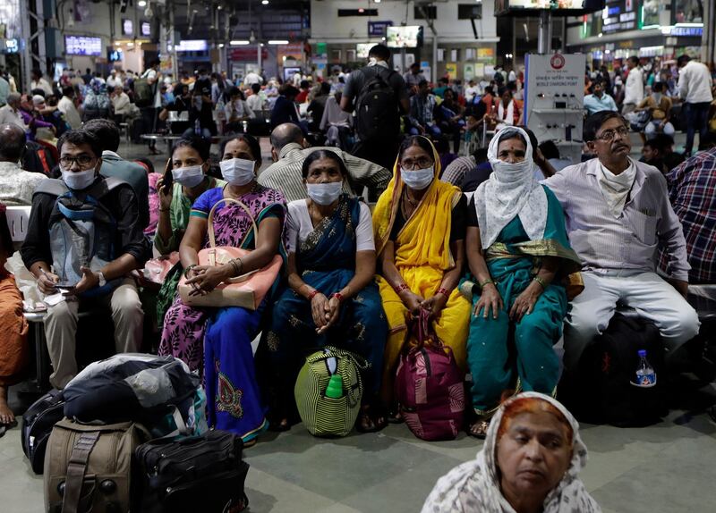 Indians waiting at a train station  in Mumbai. AP Photo