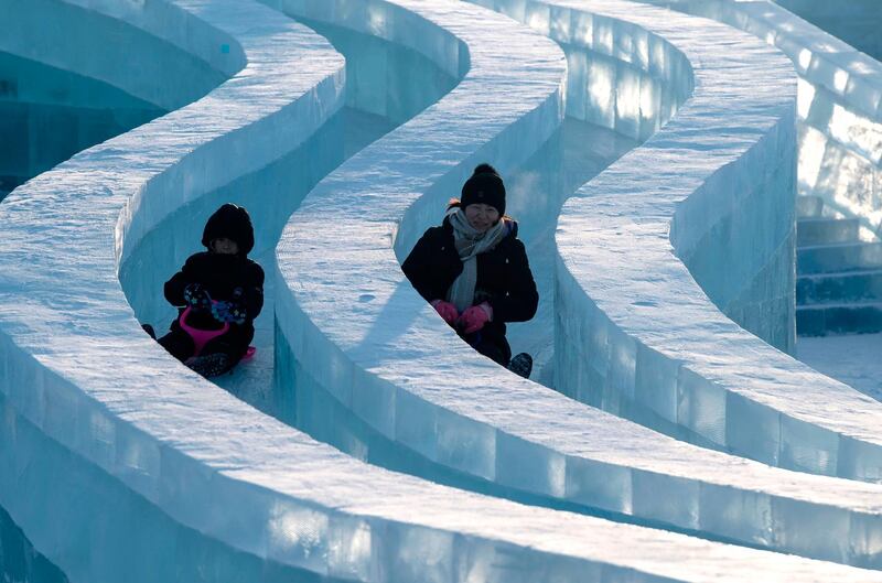 Tourists slide on an ice sculpture at the Harbin Ice and Snow World festival in Harbin, in China's northeast Heilongjiang province. AFP
