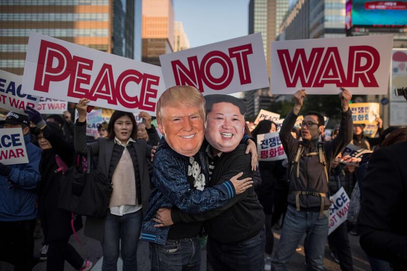 TOPSHOT - Demostrators dressed as North Korean leader Kim Jong-Un (R) and US President Donald Trump (L) embrace during a peace rally in Seoul on November 5, 2017.
Thousands of South Koreans called for peace in a protest against an upcoming visit by Donald Trump as he begins a two-week Asia tour amid tension over North Korea's weapons drive.  / AFP PHOTO / Ed JONES