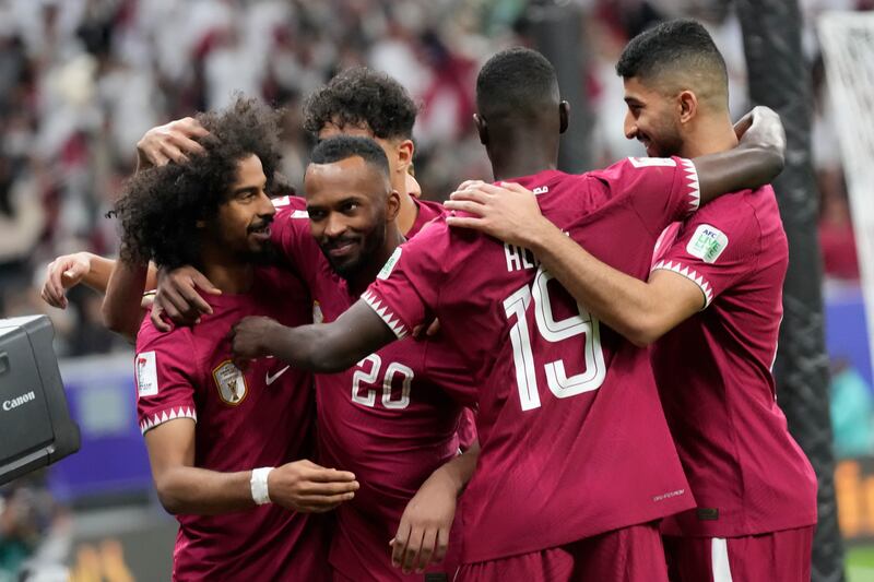 Qatar's Akram Afif, left, is congratulated by his teammates after he scored the winner from the penalty spot in the Asian Cup last-16 match against Palestine at Al Bayt Stadium in Al Khor on Monday, January 29, 2024. AP 