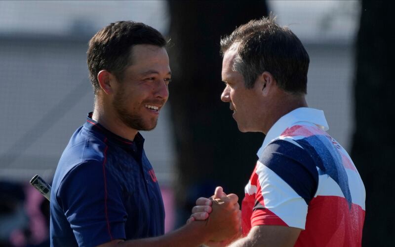 Xander Shauffele of United States, left, is congratulated by Paul Casey of Great Britain after winning gold in the men's golf.