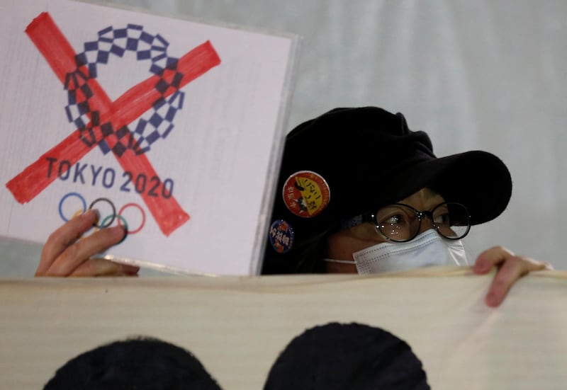 A protester demanding cancellation of the Tokyo 2020 Olympic Games holds a banner in front of the National Stadium, the main stadium of Tokyo 2020 Olympics and Paralympics, while Thomas Bach, President of the IOC visits the site in Tokyo. Reuters