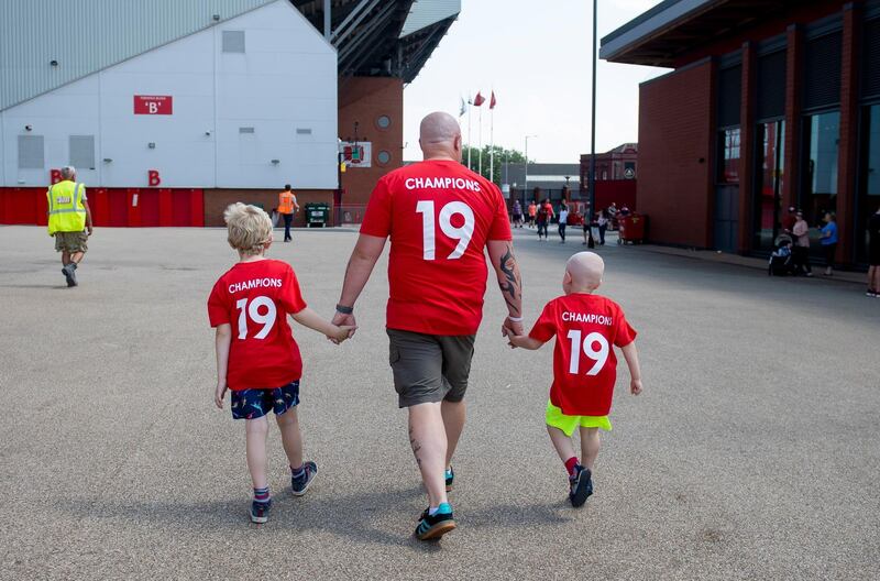 Liverpool fans of various generations celebrate outside Anfield stadium. EPA