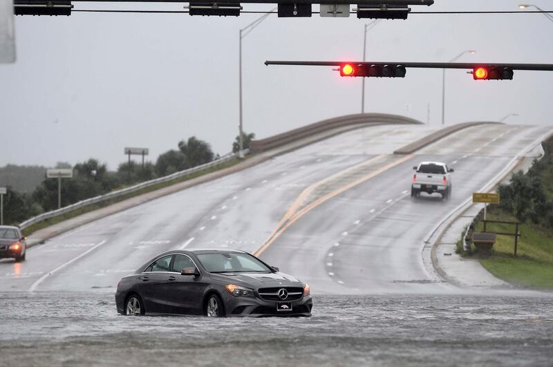 A stalled car sits near the intersection of U.S. Highway 98 and Santa Rosa Boulevard near Fort Walton Beach, Florida as wind and rain from Hurricane Sally pound the Florida's northern Gulf Coast region.  AP