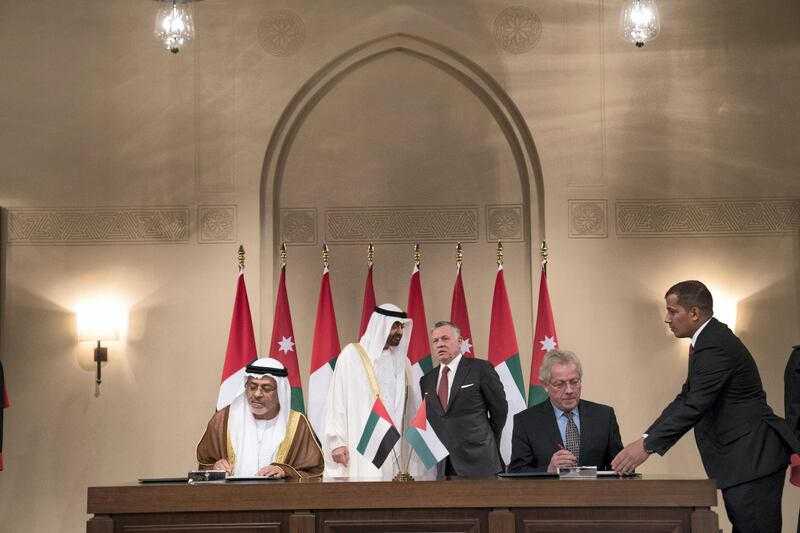ABU DHABI, UNITED ARAB EMIRATES - November 20, 2018: HH Sheikh Mohamed bin Zayed Al Nahyan, Crown Prince of Abu Dhabi and Deputy Supreme Commander of the UAE Armed Forces (back L) and HM King Abdullah II, King of Jordan (back R), witness a MOU signing, at Al Husseiniya Palace. Seen signing HE Hussain Al Nowais, Chairman of the Khalifa Fund to Support and Develop Small & Medium Enterprises (L) and Dr Fawaz Hatim Al Zu’bi, Chairman of the Board of Trustees of the Crown Prince of Jordan (2nd R).
( Mohamed Al Hammadi / Ministry of Presidential Affairs )
---