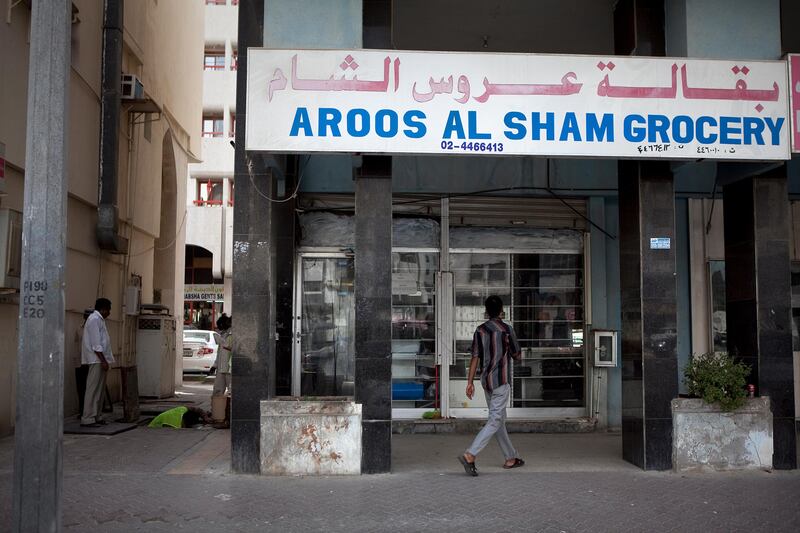 Abu Dhabi, United Arab Emirates, January 10, 2013: 
People walk by the Aroos al Sham Grocery, a recently closed convenience store on Thursday, Jan. 10, 2013, in the city block between Airport and Muroor, and Delma and Mohamed Bin Khalifa streets in Abu Dhabi. 
Silvia Razgova/The National

