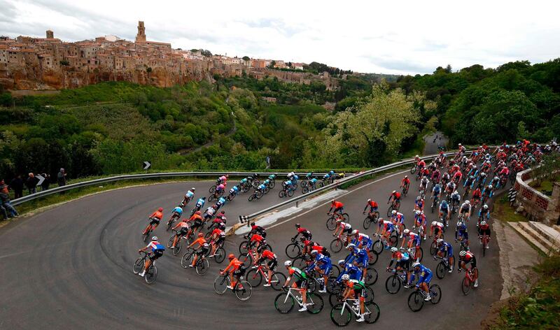 TOPSHOT - The peloton rides past Pitigliano during the stage four of the 102nd Giro d'Italia - Tour of Italy - cycle race, 235kms from Orbetello to Frascati on May 14, 2019. / AFP / Luk BENIES
