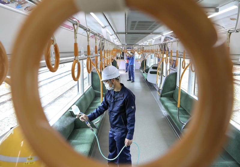 A worker sprays an antiviral liquid inside a train in Osaka, western Japan. REUTERS