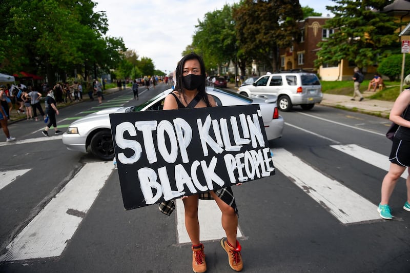 Amy Gee of Minneapolis holds a sign near the scene of the arrest of George Floyd, who later died in police custody, in Minneapolis, Minnesota, USA.  EPA