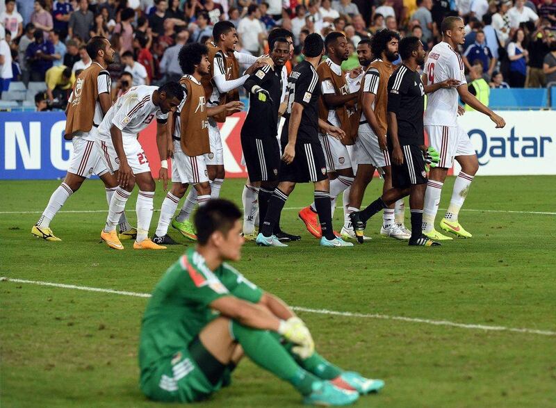 UAE players celebrate victory over Japan as Japanese keeper Eiji Kawashima looks on after their Asian Cup quarter-final match on Friday. Saeed Khan / AFP