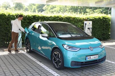 DRESDEN, GERMANY - JUNE 08: A Volkswagen employee demonstrates the charging of a Volkswagen ID.3 electric car outside the "GlÃ¤serne Manufaktur" ("Glass Manufactory") production facility on June 08, 2021 in Dresden, Germany. The Dresden plant is currently churning out 35 ID.3 cars per day. The ID.3 and ID.4 cars are also produced at VW's Zwickau plat located in the same region.  (Photo by Sean Gallup/Getty Images)
