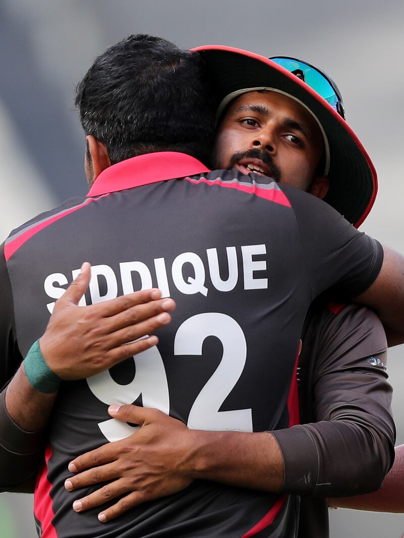 UAE's Junaid Siddique is congratulated after taking the wicket of Nepal's Karan KC. 