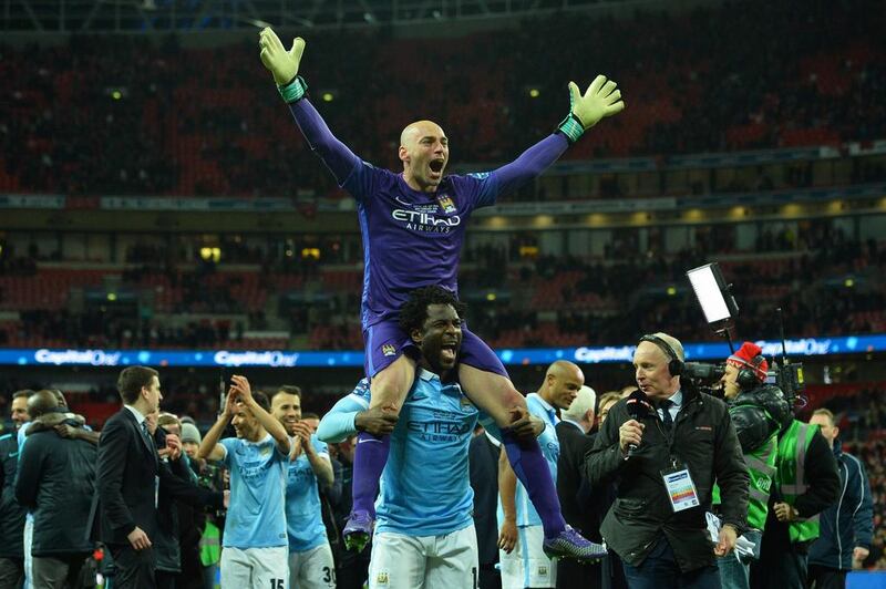 Manchester City’s Argentinian goalkeeper Willy Caballero (top) celebrates on the shoulders of Manchester City’s Ivorian striker Wilfried Bony (C bottom) after he saved three penalties in the penalty shoot-out to help Manchester City win the English League Cup final football match between Liverpool and Manchester City at Wembley Stadium in London on February 28, 2016. AFP / GLYN KIRK