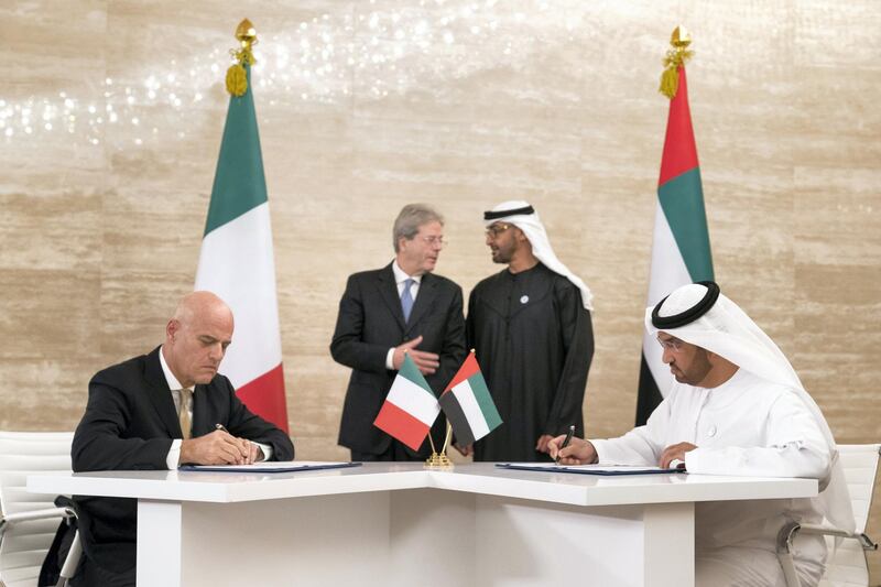 ABU DHABI, UNITED ARAB EMIRATES -  March 11, 2018: HH Sheikh Mohamed bin Zayed Al Nahyan, Crown Prince of Abu Dhabi and Deputy Supreme Commander of the UAE Armed Forces (back center R), and HE Paolo Gentiloni Silveri, Prime Minister of Italy (back center L), witness the signing of a memorandum of understanding (MOU), between Mubadala and Eni, at Al Shati Palace. Seen signing are HE Dr Sultan Ahmed Al Jaber, UAE Minister of State, Chairman of Masdar and CEO of ADNOC Group (R), and Claudio Descalzi CEO of Eni (L).  
( Ryan Carter for the Crown Prince Court - Abu Dhabi )
---