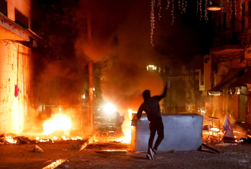 A Palestinian throws stones as the Israeli army during an early morning raid in Ramallah on Thursday. Reuters