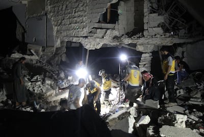 Rescue workers known as White Helmets inspect the rubble of a building during a search for survivors following Syrian government forces air strikes in the rebel town of Orum al-Kubra, in the northern province of Aleppo, late on August 10, 2018. - Heavy bombardment killed nearly 30 civilians across northern Syria yesterday, a monitor said, in some of the fiercest shelling of rebel-held areas there in months. (Photo by Amer ALHAMWE / AFP)