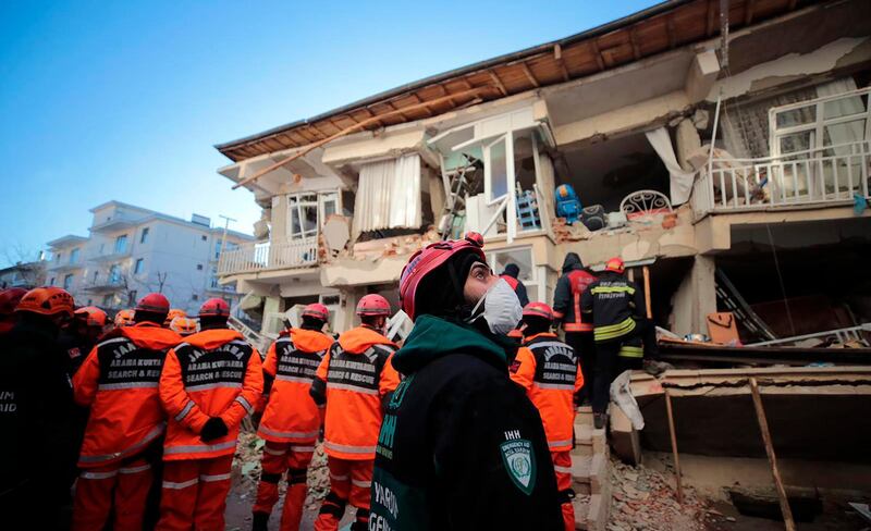 Rescuers search for people buried under the rubble on a collapsed building, after an earthquake struck Elazig, eastern Turkey. AP