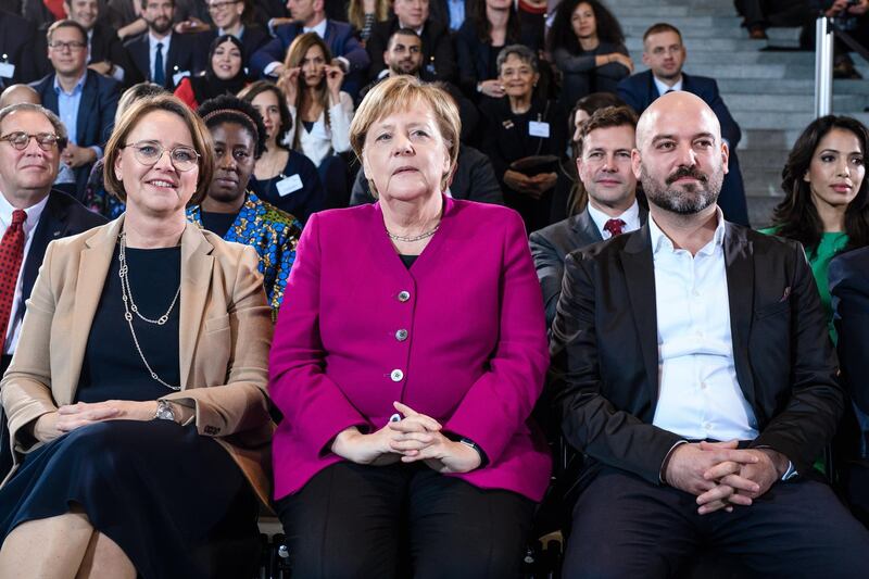 epa07129803 German Chancellor Angela Merkel (C) sits next to German State Secretary for Migration, Refugees and Integration Annette Widmann-Mauz (L) and Gal Rachman of IsraAID Germany e.V (R) during an award ceremony for the National Integration Prize at the chancellery in Berlin, Germany, 29 October 2018. The National Integration Prize is awarded by the German chancellor for achievements in integration.  EPA/CLEMENS BILAN