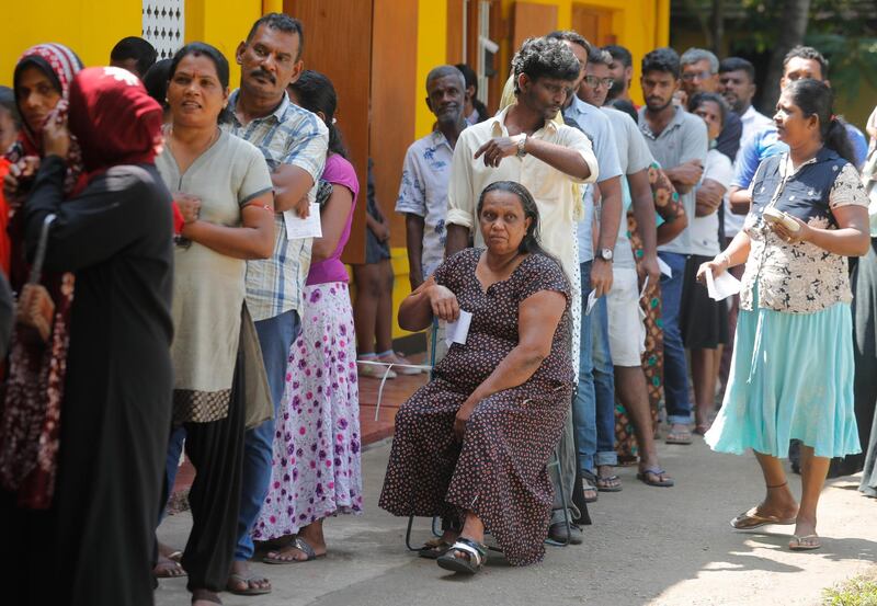 Sri Lankans queue up to cast their votes at a polling station during the presidential election in Colombo, Sri Lanka, Saturday, Nov. 16, 2019.  A convoy of buses carrying Muslim voters traveling in northern Sri Lanka was attacked by gunfire and stones, and blocked by burning tires, around midnight on Saturday hours before polls opened in Sri Lankaâ€™s presidential election. (AP Photo/Eranga Jayawardena)