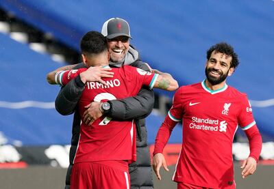 Liverpool's manager Jurgen Klopp, center, celebrates with Liverpool's Roberto Firmino, front, and Liverpool's Mohamed Salah at the end of the English Premier League soccer match between West Bromwich Albion and Liverpool at the Hawthorns stadium in West Bromwich, England, Sunday, May 16, 2021. (Tim Keeton/Pool via AP)