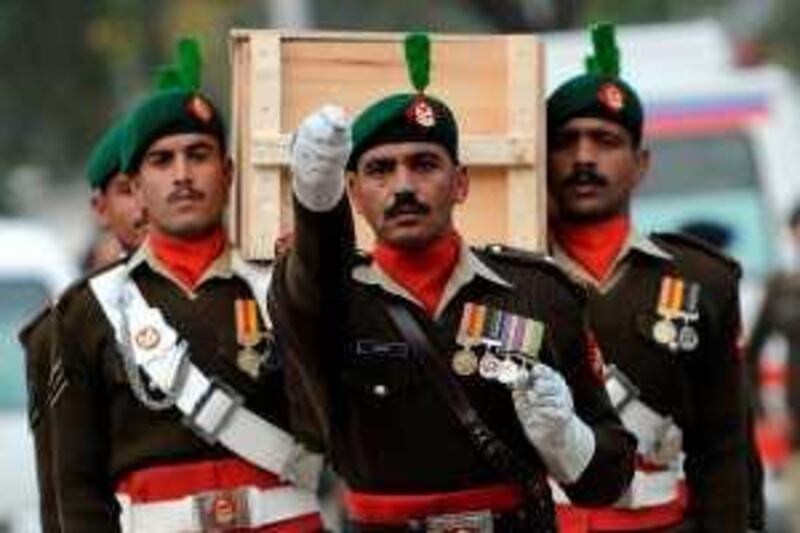 Pakistani army soldiers march as they carry a coffin during the funeral of army personell who were killed in a Mosque attack in the garrison city of Rawalpindi on December 5, 2009.  Suicide bombers stormed a mosque frequented by army officers in Pakistan's garrison city of Rawalpindi on December 4, leaving 40 people dead in an onslaught of gunfire, grenades and explosions.   AFP PHOTO/Farooq NAEEM *** Local Caption ***  386406-01-08.jpg