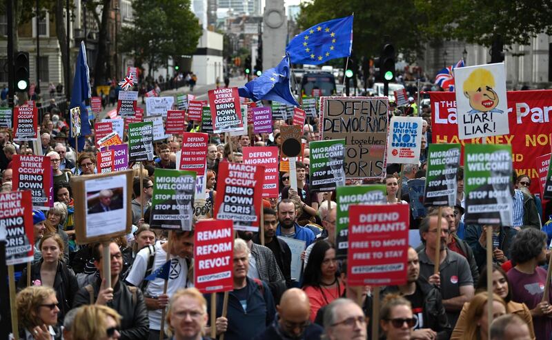 Activists hold placards and wave EU flags during an anti-government protest calling for the Prime Minister's resignation, outside Downing Street in central London on September 7, 2019.  Britain's upper house on Friday gave final approval to a law that would force Boris Johnson to delay Brexit, in a fresh setback for the British Prime Minister who is struggling in his bid to call an early election. / AFP / DANIEL LEAL-OLIVAS
