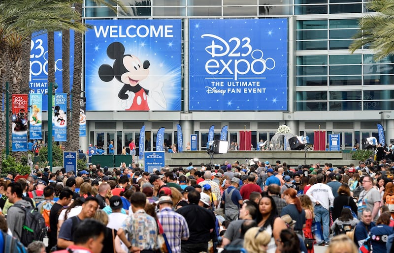 A crowd of people wait to enter the D23 Expo as crews do interviews outside the Anaheim Convention Center in Anaheim, Calif., on Friday, July 14, 2017. (Jeff Gritchen/The Orange County Register via AP)