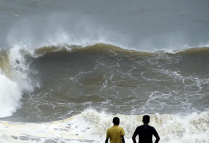 TOPSHOT - Sri Lankan residents walk during a heavy rain and strong winds in Colombo on November 30, 2017.
A major storm left three dead, two missing and more than a dozen injured across Sri Lanka, authorities said on November 30, as powerful winds toppled trees and damaged buildings. / AFP PHOTO / ISHARA S. KODIKARA