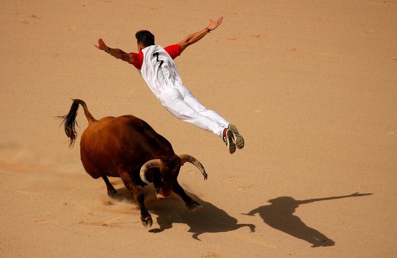 A recortador jumps over a bull during a contest in a bullring at the San Fermin festival in Pamplona, Spain.  Reuters