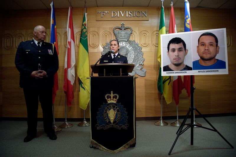 Assistant Commissioner Rhonda Blackmore speaks while Regina Police Chief Evan Bray, left, looks on during a press conference at RCMP "F" Division Headquarters in Regina, Saskatchewan, on Sunday, Sept.  4, 2022.  Damien Sanderson and Myles Sanderson allegedly stabbed and killed 10 people between James Smith Cree Nation and Weldon, Saskatchewan, on Sunday morning, and the pair are presently at large.  (Michael Bell / The Canadian Press via AP)