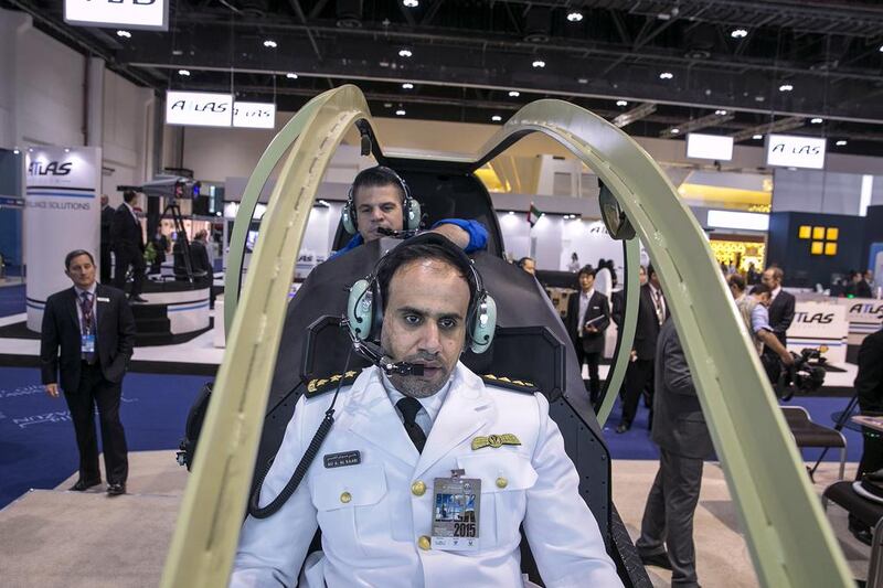 Captain Ali Al Kaabi, UAE Navy, tries his hand in piloting an AH1Z attack helicopter simulator at the Bell stand. Silvia Razgova / The National