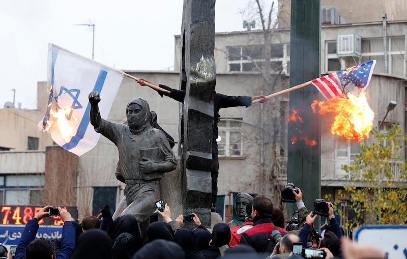 epa08102097 Iranians burn US and Israel flags during anti-US protests over killing late Iranian Revolutionary Guards Corps (IRGC) Lieutenant general and commander of the Quds Force Qassem Soleimani  in Tehran, Iran, 04 January 2020. The Pentagon announced that Iran's Quds Force leader Qasem Soleimani and Iraqi militia commander Abu Mahdi al-Muhandis were killed on 03 January 2020 following a US airstrike at Baghdad's international airport. The attack comes amid escalating tensions between Tehran and Washington  EPA/ABEDIN TAHERKENAREH
