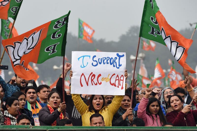 Supporters of the Bharatiya Janata Party (BJP) wave party flags and hold placards in support of the government's Citizenship Amendment Act (CAA) and the National Register of Citizens (NRC) during a rally in New Delh.   AFP