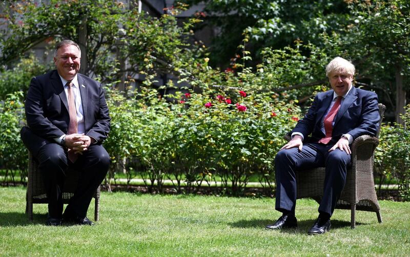 TOPSHOT - US Secretary of State Mike Pompeo (L) and Britain's Prime Minister Boris Johnson sit in socially distanced chairs in the garden of 10 Downing street in central London on July 21, 2020. / AFP / POOL / HANNAH MCKAY
