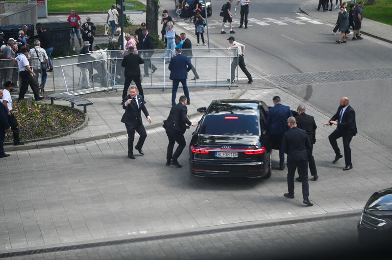 Security officers put Mr Fico into a car after the shooting at a Slovak government meeting. Reuters